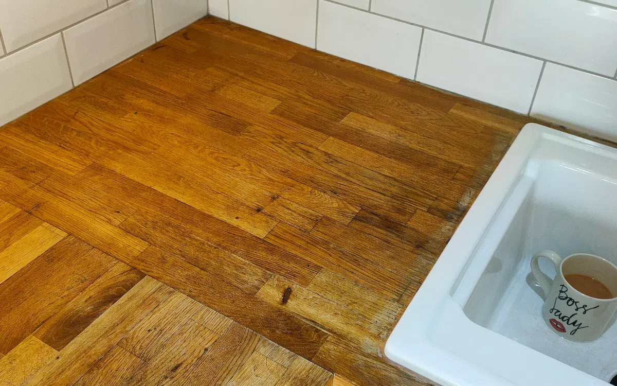 Worn solid wood worktop before professional restoration